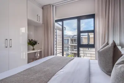 a bedroom with a bed and a large window at Oceanfront Escape with mountain views in Hermanus