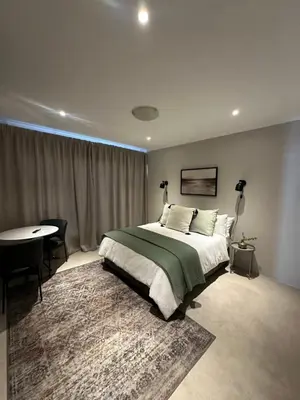 a bedroom with a bed and a table and a desk at The Peaceful Nook Somerset 2 in Somerset West