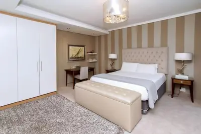 a bedroom with a large white bed and a couch at Luxury Penthouse -Crystal Towers in Cape Town
