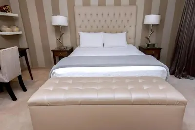 a bedroom with a large white bed with a white tufted couch at Luxury Penthouse -Crystal Towers in Cape Town