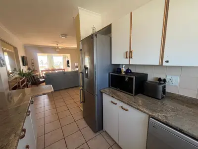 a kitchen with white cabinets and a refrigerator at Greenways Getaway in Gordonʼs Bay