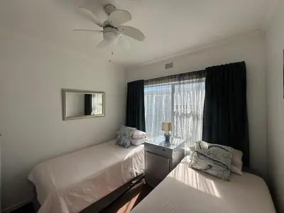 a bedroom with two beds and a window at Greenways Getaway in Gordonʼs Bay