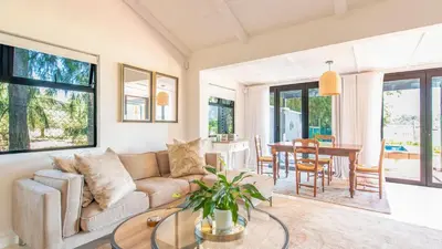 a living room with a couch and a table at Franschhoek Homestead Cottage in Groendal