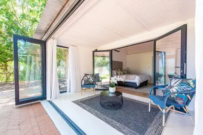 a room with a bed and a room with glass doors at Franschhoek Homestead Cottage in Groendal