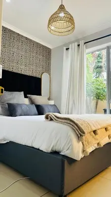 a bedroom with a large bed with a large window at Hideaway Haven 2 in Cape Town