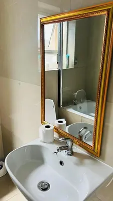 a bathroom with a white sink and a mirror at Hideaway Haven 2 in Cape Town