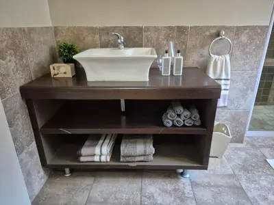 a bathroom vanity with a sink and towels at Mistys Apartment Durbanville in Durbanville