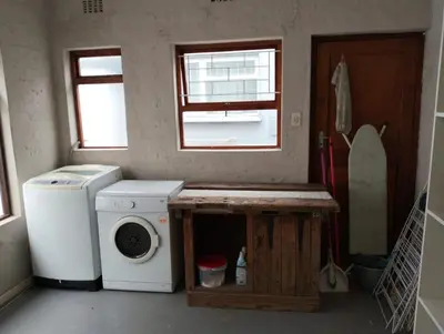 a laundry room with a washing machine and a window at Dawson78 in Hermanus