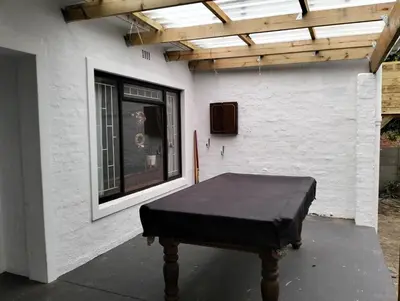 a table in front of a building with a window at Dawson78 in Hermanus