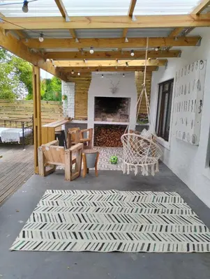 an outdoor patio with a fireplace and a swing at Dawson78 in Hermanus
