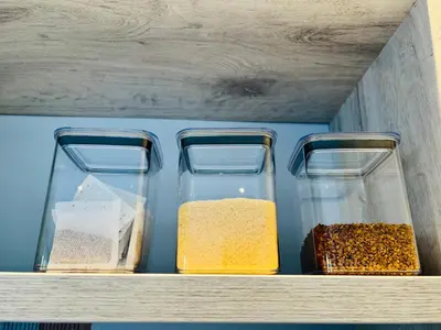 a shelf with four glass containers filled with different spices at Rissie's Place in Gordonʼs Bay