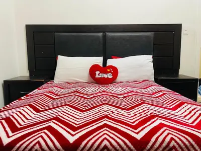 a red heart pillow sitting on top of a bed at ANNIKA B&B Claremont in Cape Town
