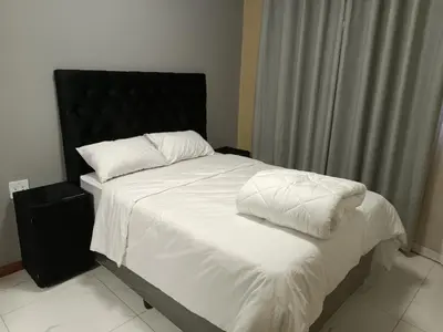 a bedroom with a bed with white sheets and pillows at Spring forth guest house in De Grendel