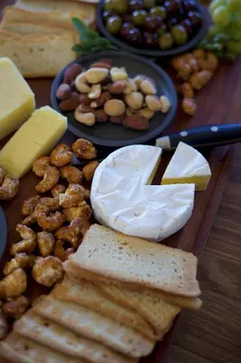 a table with cheese and bread and other foods at Skaam Cabin Luxe Hideaway with a Naughty Side in Wolseley