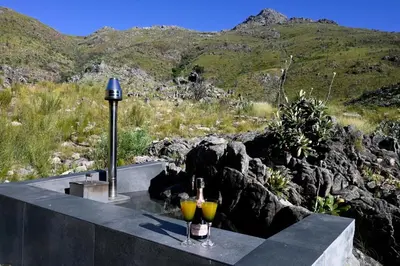 two glasses of wine sitting on top of a table at Skaam Cabin Luxe Hideaway with a Naughty Side in Wolseley