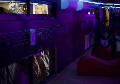 a dark room with a fireplace and purple lighting at Skaam Cabin Luxe Hideaway with a Naughty Side in Wolseley