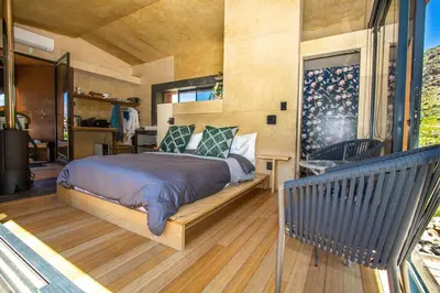 a master bedroom with a bed and a balcony at Skaam Cabin Luxe Hideaway with a Naughty Side in Wolseley