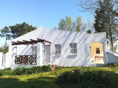 a white house with a gambrel roof at Zevenwacht Cottages in Kuilsrivier
