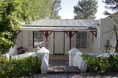 a house with a white door and a porch at Zevenwacht Cottages in Kuilsrivier