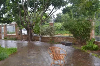 a chair sitting in the rain in a yard at Stellenhof Inn - walking distance to town center in Stellenbosch