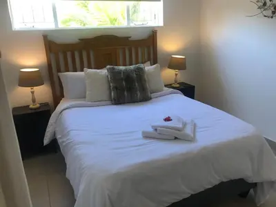 a bedroom with a white bed with towels on it at Stellenhof Inn - walking distance to town center in Stellenbosch