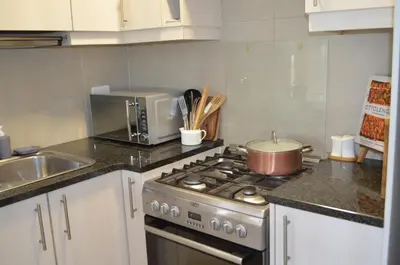 a kitchen with a stove with a pot on it at Stellenhof Inn - walking distance to town center in Stellenbosch
