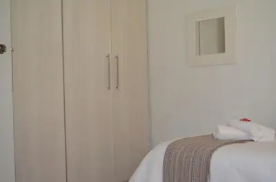 a bedroom with a white cabinet and a bed at Stellenhof Inn - walking distance to town center in Stellenbosch
