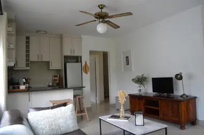 a living room with a couch and a kitchen at Stellenhof Inn - walking distance to town center in Stellenbosch