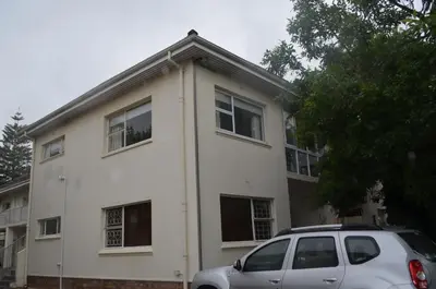 a white house with a car parked in front of it at Stellenhof Inn - walking distance to town center in Stellenbosch