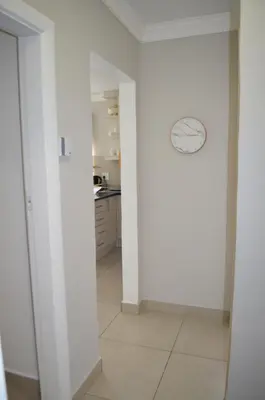 a hallway with a white wall and a kitchen at Stellenhof Inn - walking distance to town center in Stellenbosch