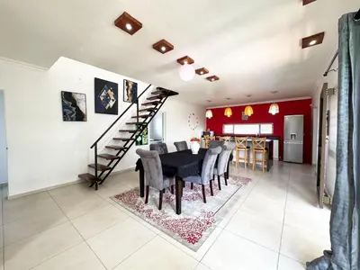 a dining room with a table and chairs and a staircase at Spacious Shared 3-Bedroom Villa Near Bloubergstrand Beach with Pool & Free Wi-Fi in Cape Town
