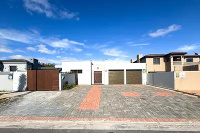 an empty parking lot in front of a house at Spacious Shared 3-Bedroom Villa Near Bloubergstrand Beach with Pool & Free Wi-Fi in Cape Town