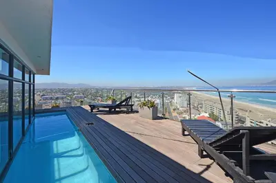a house with a swimming pool and a view of the beach at Aquarius 2 Bedroom Luxury Apartment in Cape Town