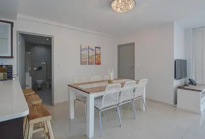 a dining room with a table and chairs at Aquarius 2 Bedroom Luxury Apartment in Cape Town