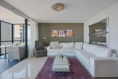 a living room with a white couch and a table at Aquarius 2 Bedroom Luxury Apartment in Cape Town