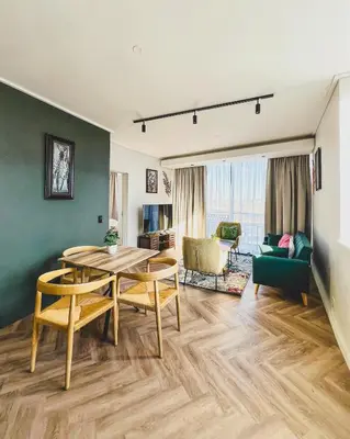 a living room with a table and a dining room at Bethany Apartment ON PARK Century City in Cape Town