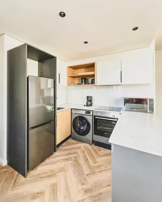 a kitchen with a stainless steel refrigerator and a dishwasher at Bethany Apartment ON PARK Century City in Cape Town