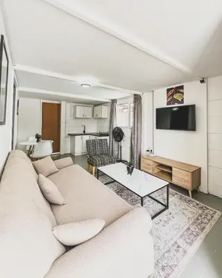 a living room with a couch and a tv at Cedar Apartments on Century City in Cape Town