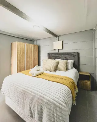 a bedroom with a large bed with white sheets and pillows at Cedar Apartments on Century City in Cape Town
