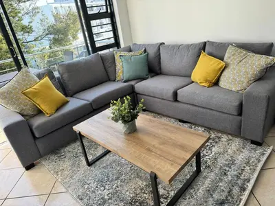 a living room with a couch and a coffee table at Peaceful 2-Bed Apartment in Boubergstrand in Cape Town