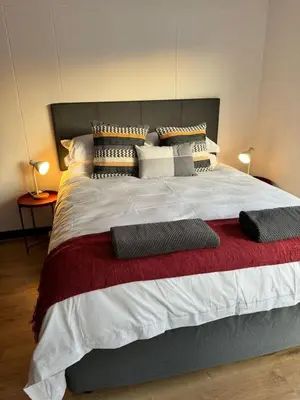 a bedroom with a large bed with pillows on it at Peaceful 2-Bed Apartment in Boubergstrand in Cape Town