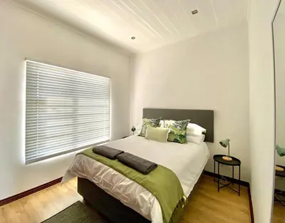a bedroom with a large bed and a window at Peaceful 2-Bed Apartment in Boubergstrand in Cape Town