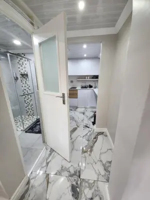 a bathroom with a white door and a marble floor at Cosy Nook in Cape Town
