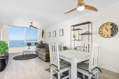 a living room with a table and chairs and a clock at Odeon Towers 808 by Host Agents in Cape Town
