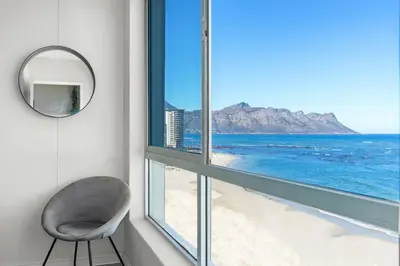 a chair sitting next to a window with a view of the ocean at Odeon Towers 808 by Host Agents in Cape Town