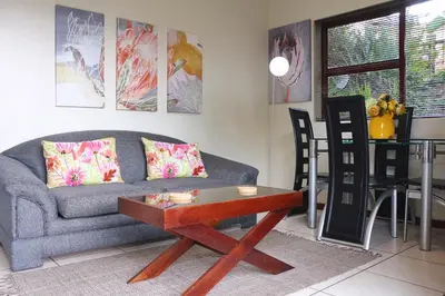 a living room with a couch and a table at Tyger Classique Self-Catering Cape Town, Tyger Valley in Bellville