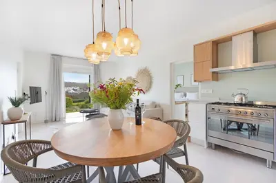 a kitchen and dining room with a wooden table and chairs at Winelands Golf Lodges 5 in Stellenbosch