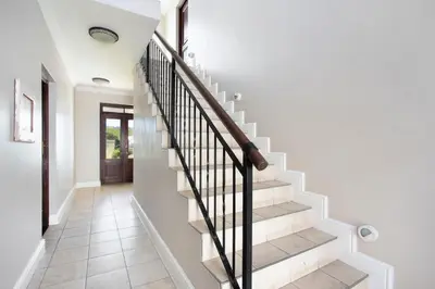 a staircase in a home with white walls and white floors at Winelands Golf Lodges 8 in Stellenbosch
