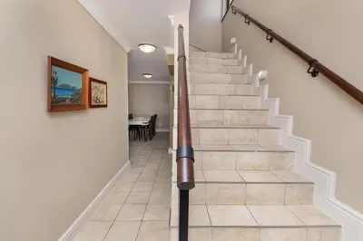 a spiral staircase in a house with a dining room at Winelands Golf Lodges 13 in Stellenbosch