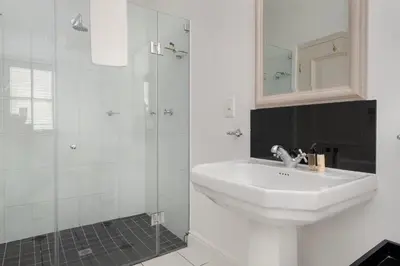 a white bathroom with a sink and a shower at Winelands Golf Lodges 13 in Stellenbosch